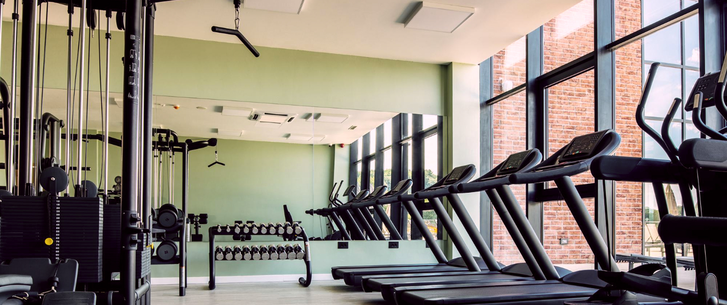 Фото современного спортзала с беговыми дорожками, гантелями и вертикальным блоком